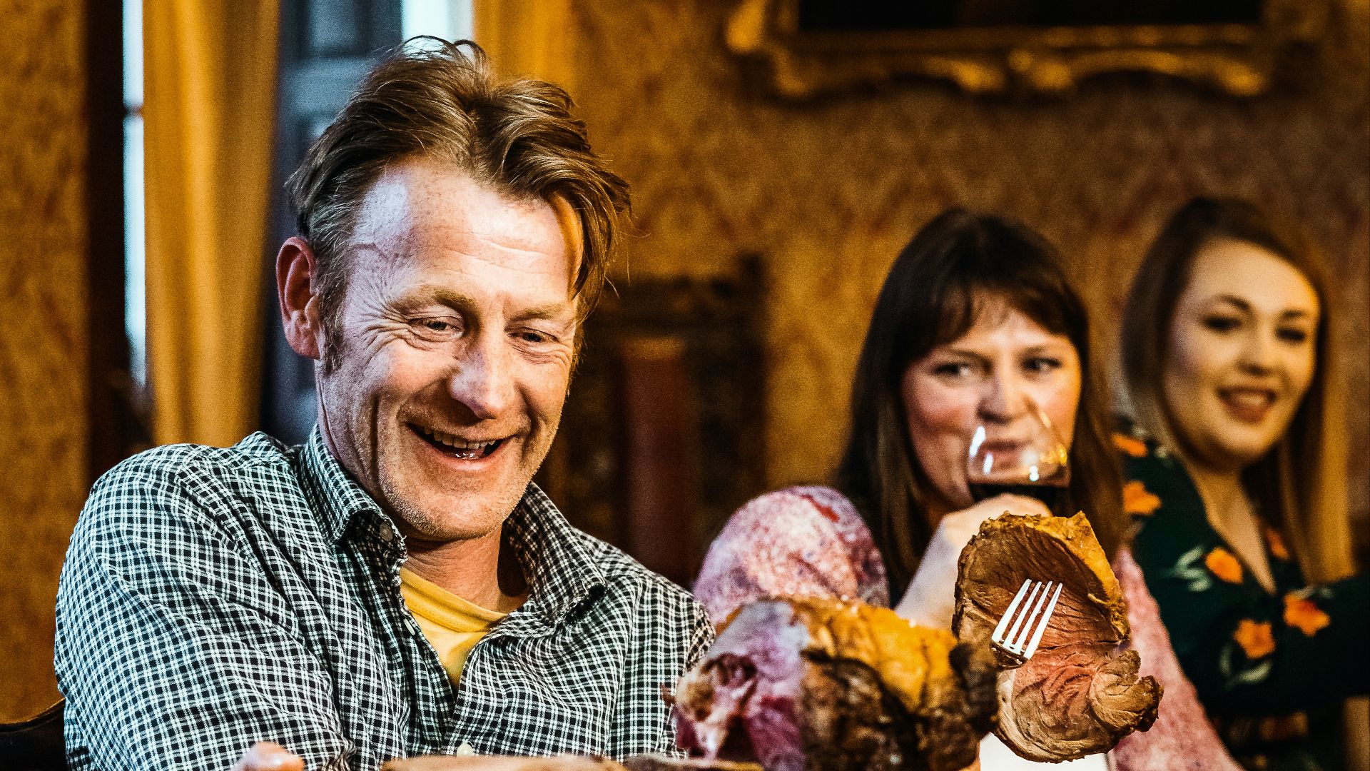 man in blue and white checkered button up shirt holding bread