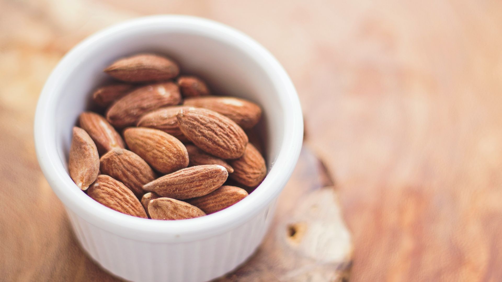 shallow focus photography of almonds in white ceramic bowl