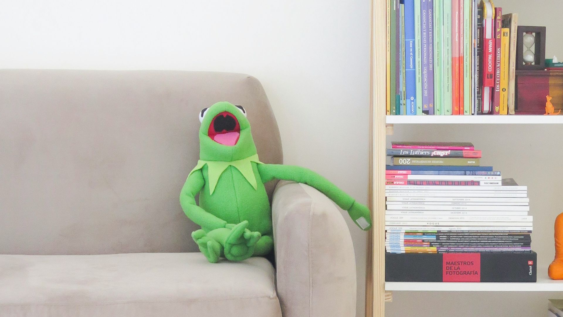 The Muppets Kermit plush toy on gray sofa