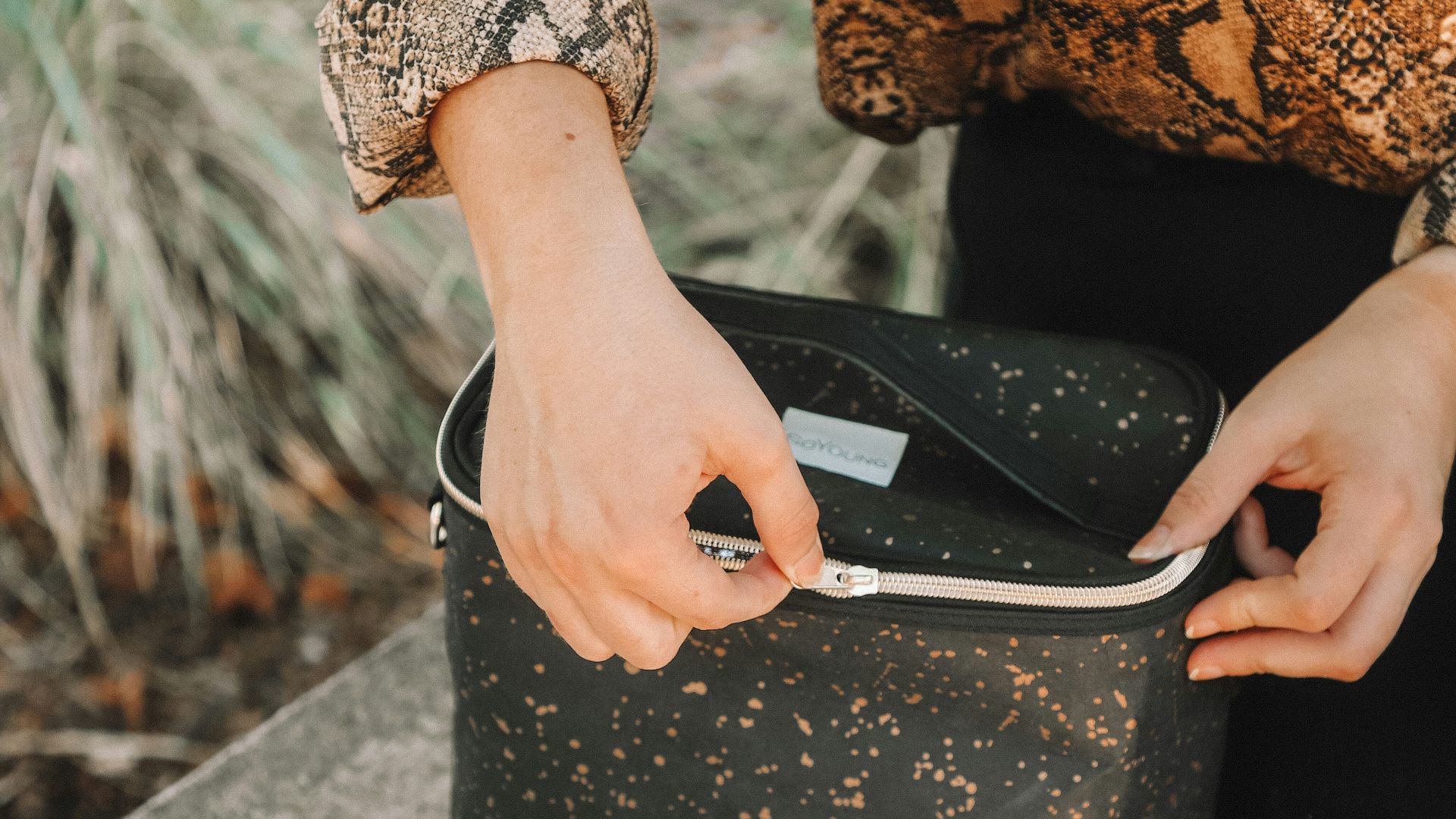woman opening lunch bag near bowl of salad