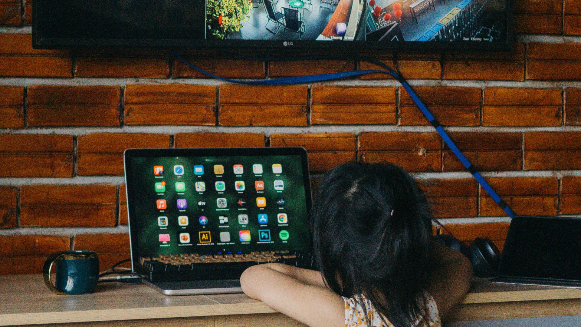 a little girl sitting in front of a laptop computer