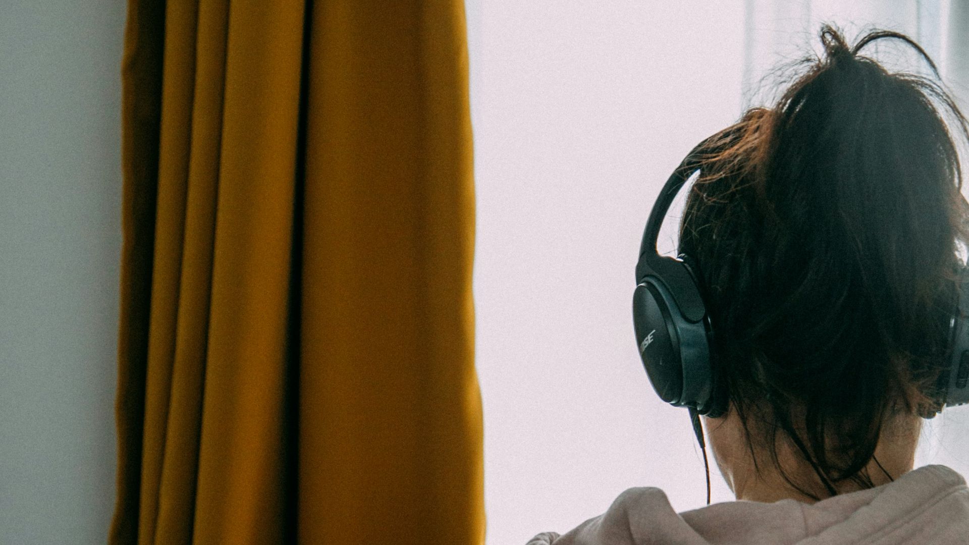 woman in gray shirt wearing black headphones
