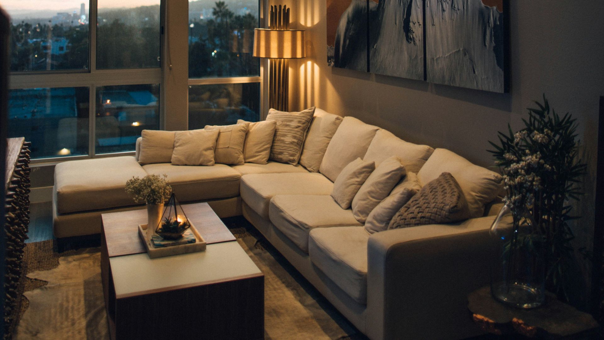 gray padded chaise couch beside window