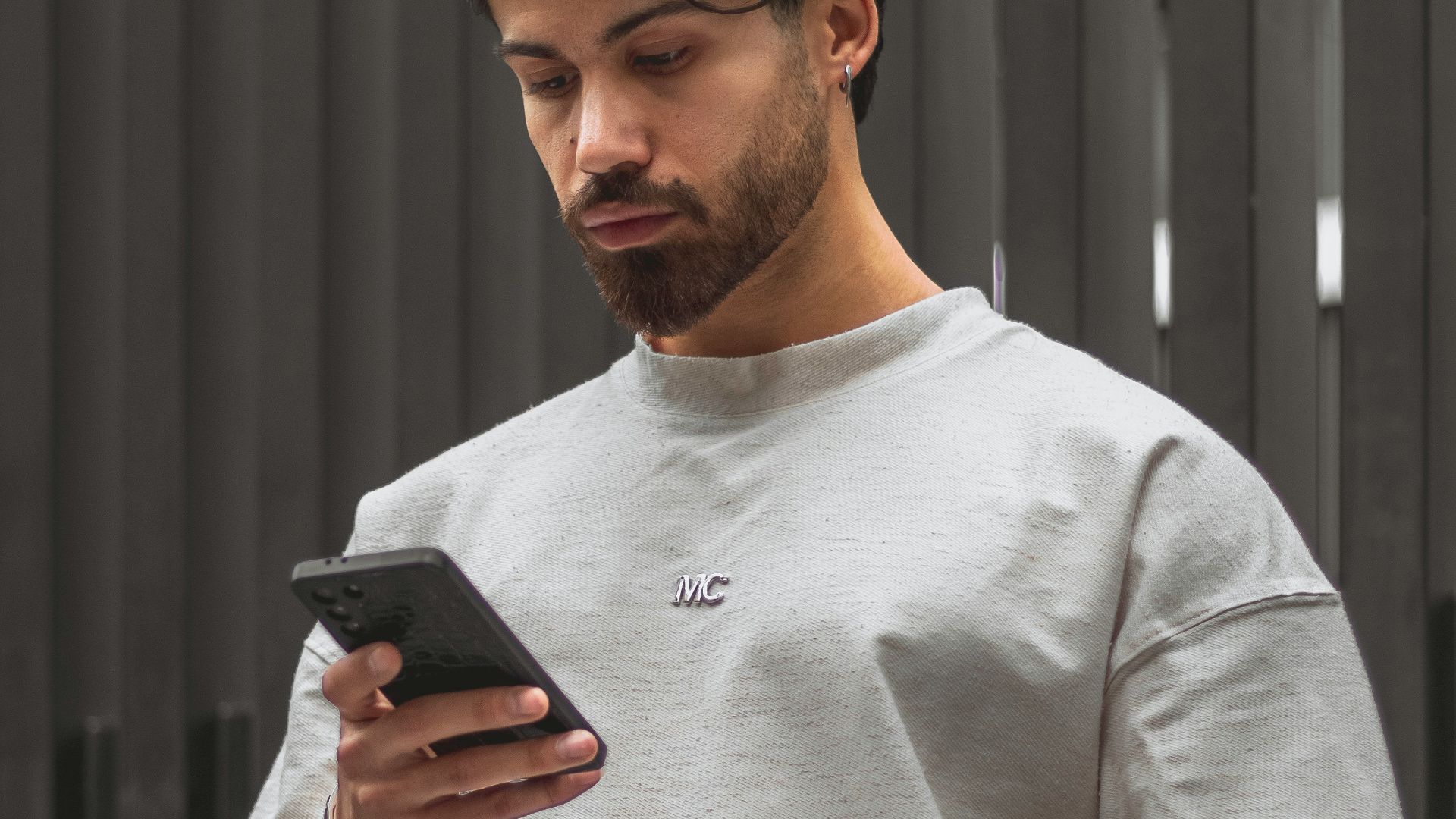 Man looking at his phone with a serious expression.