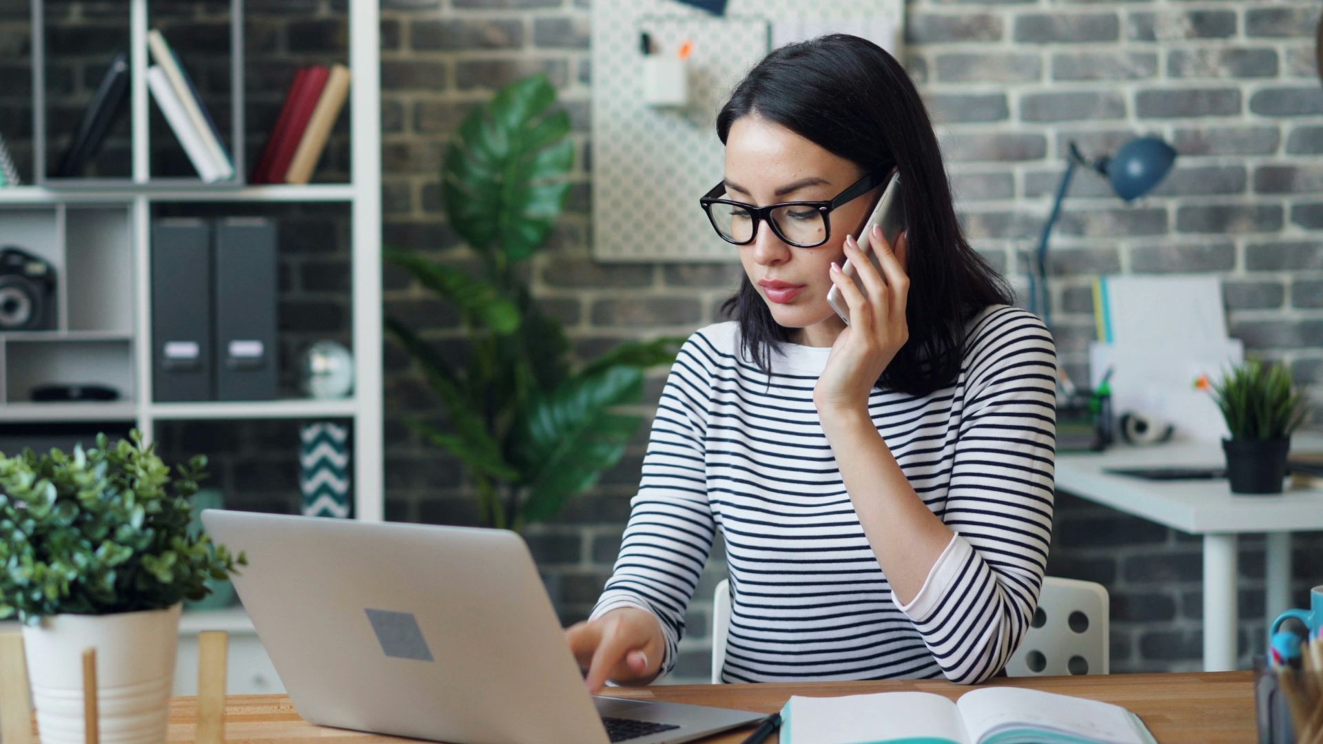 a woman sitting at a desk using a laptop computer