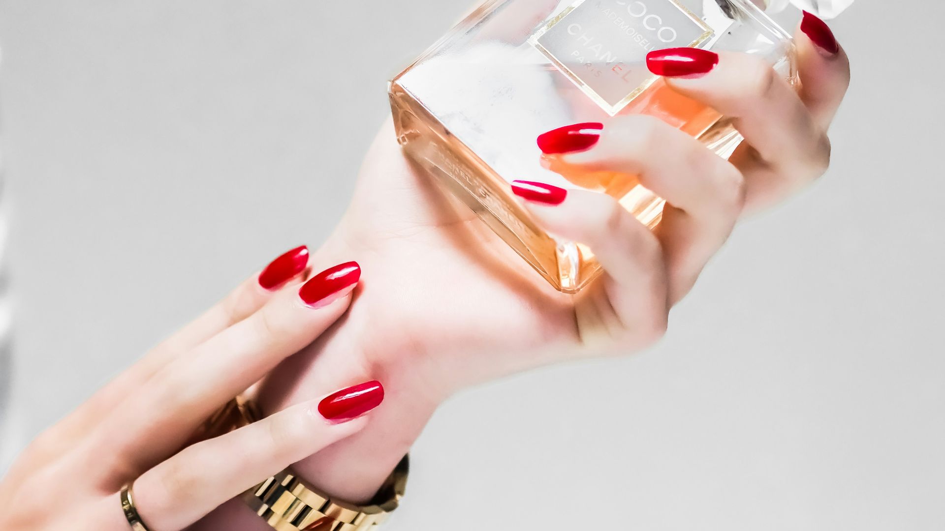 person holding clear glass bottle