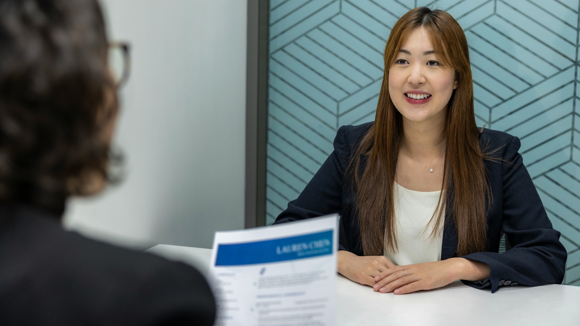 a woman sitting at a table with a piece of paper in front of her