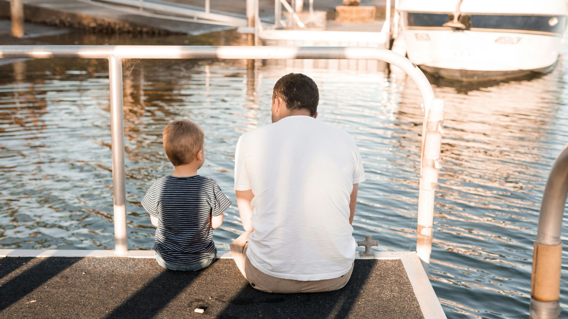 man and boy sitting on dock