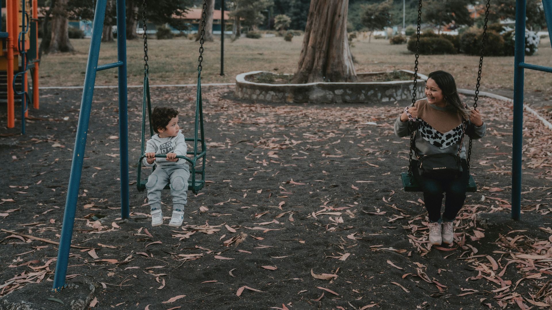 2 children sitting on swing during daytime