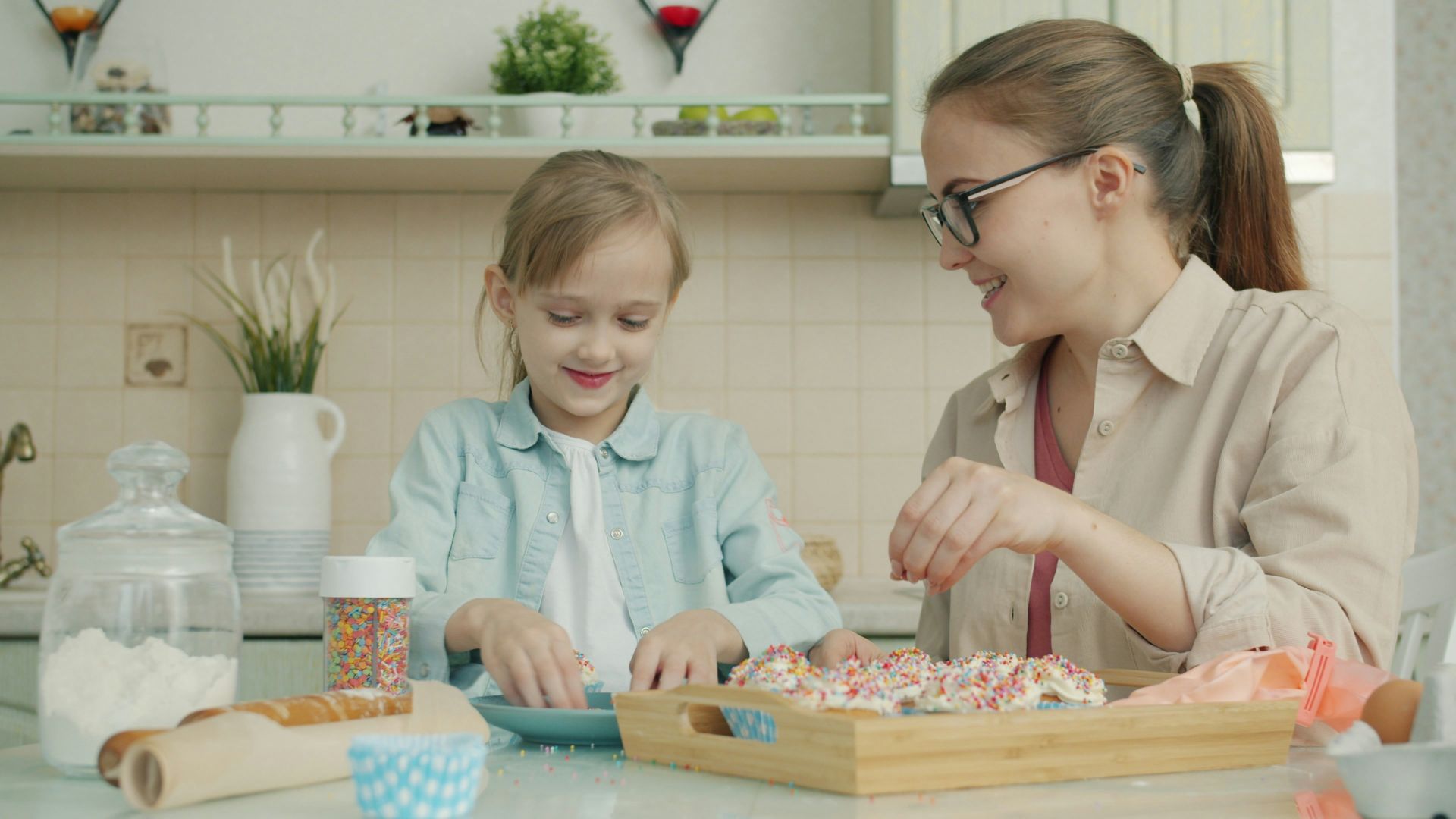 Mother and daughter decorating cookies in the kitchen
