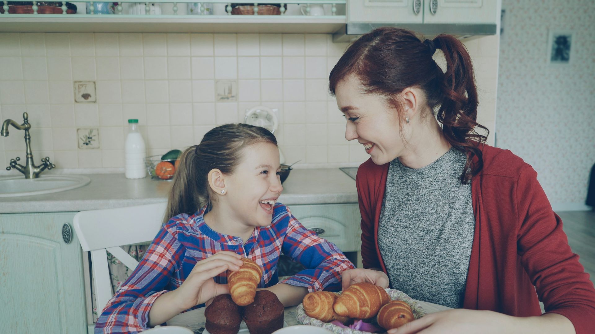 Two girls enjoying breakfast together at the table.