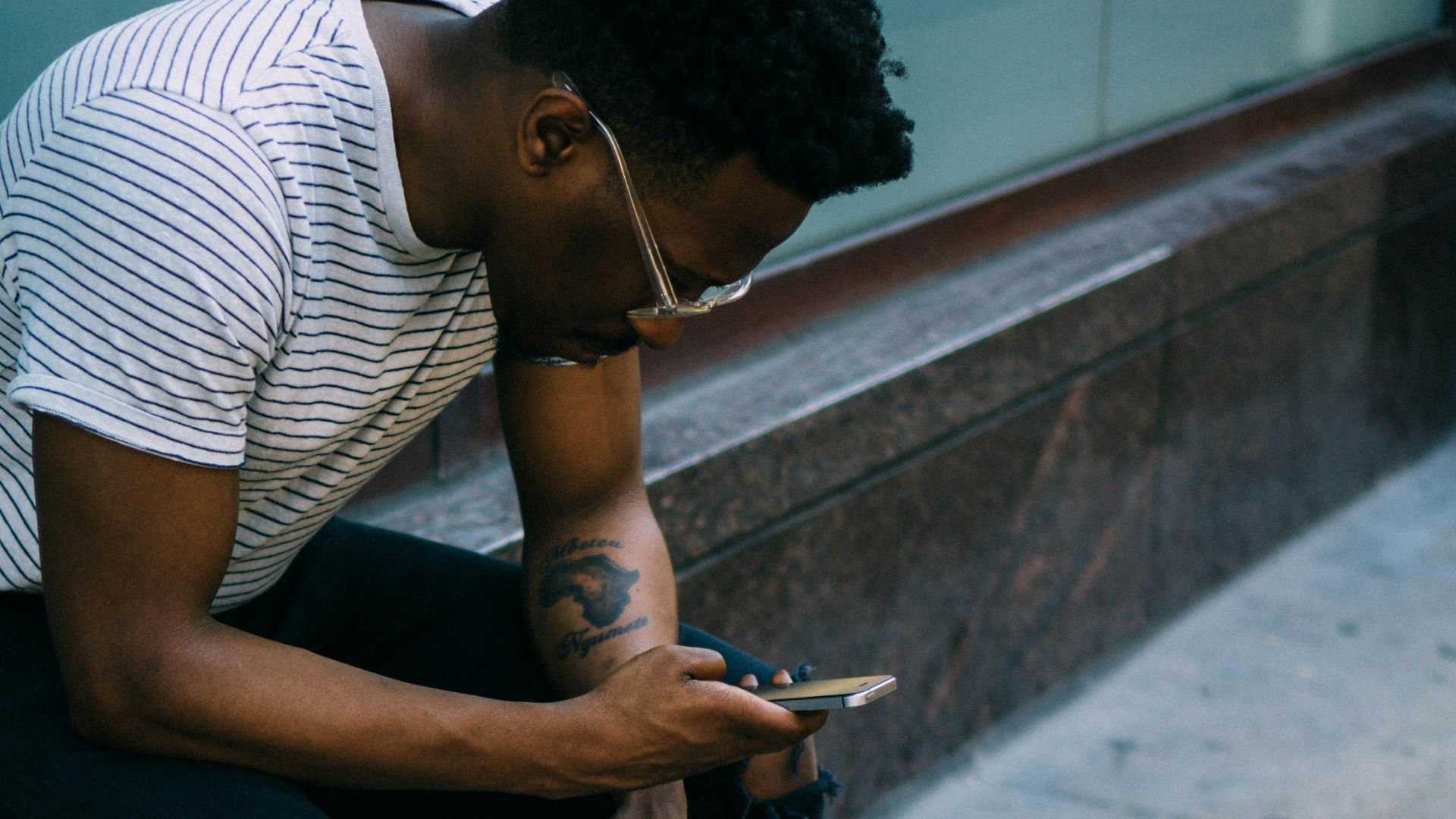 man sitting while using phone