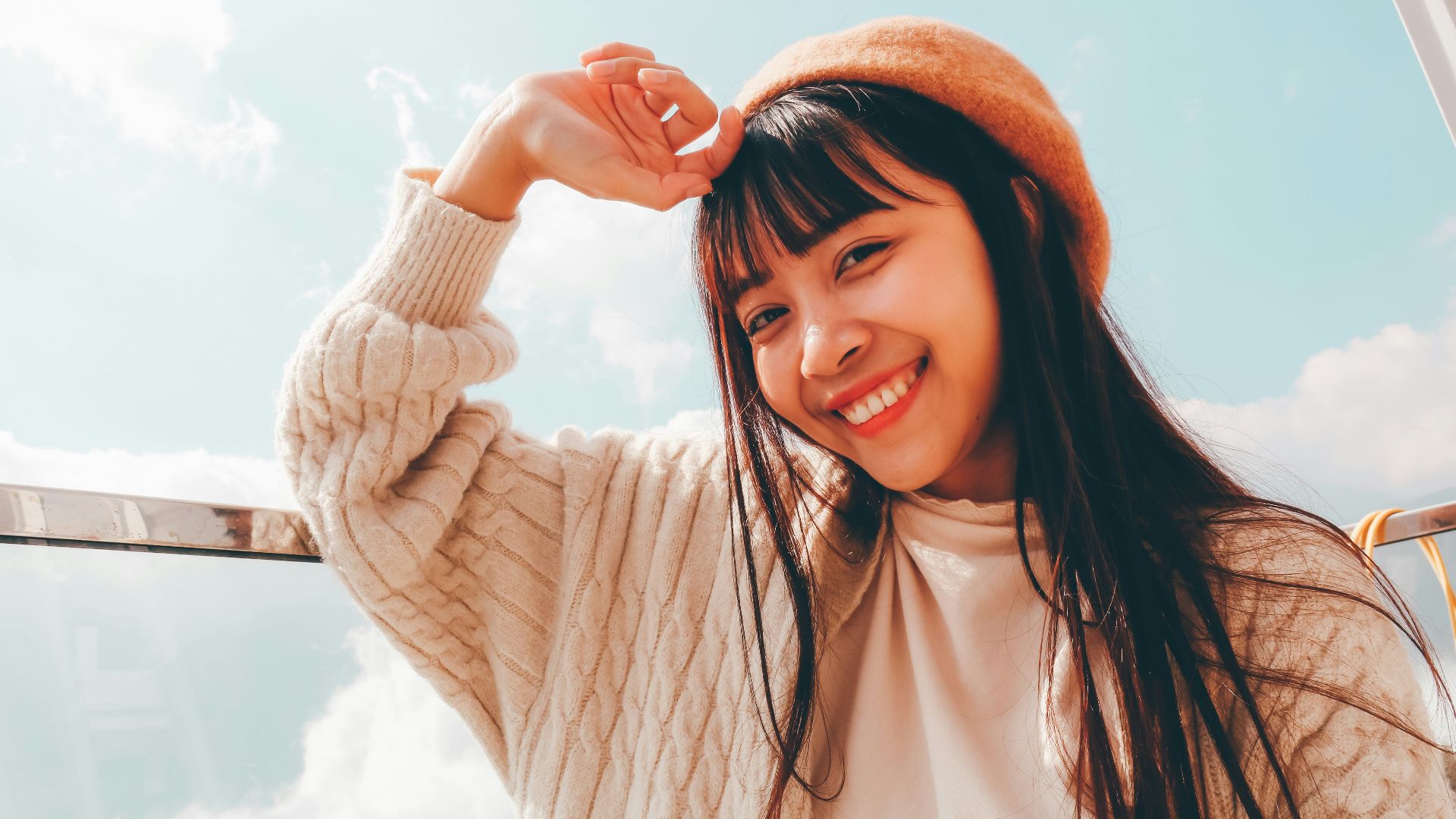 woman in white long sleeve shirt and orange knit cap