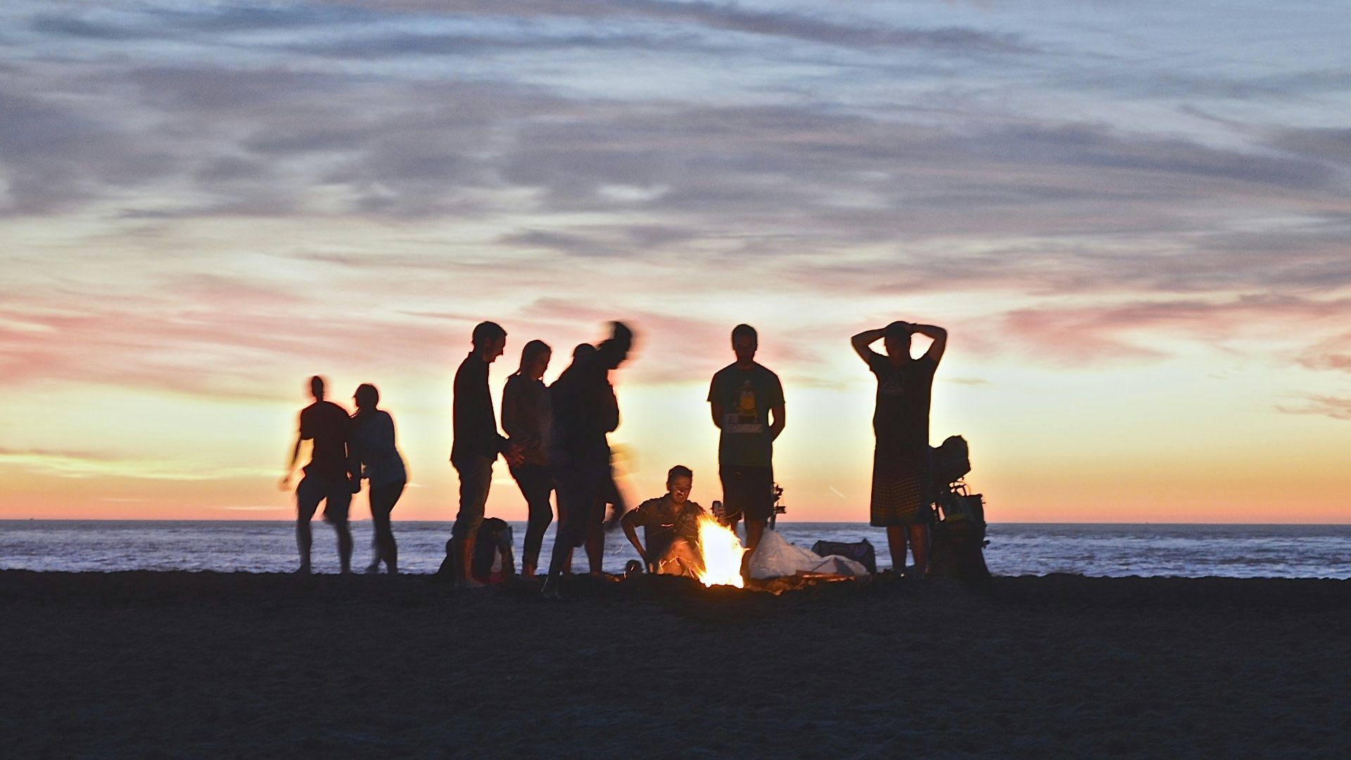 group of people setting up campfire
