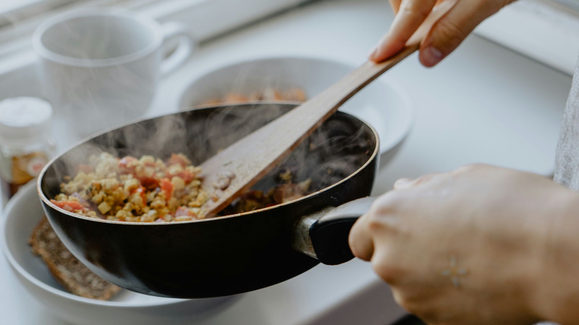 person holding black frying pan