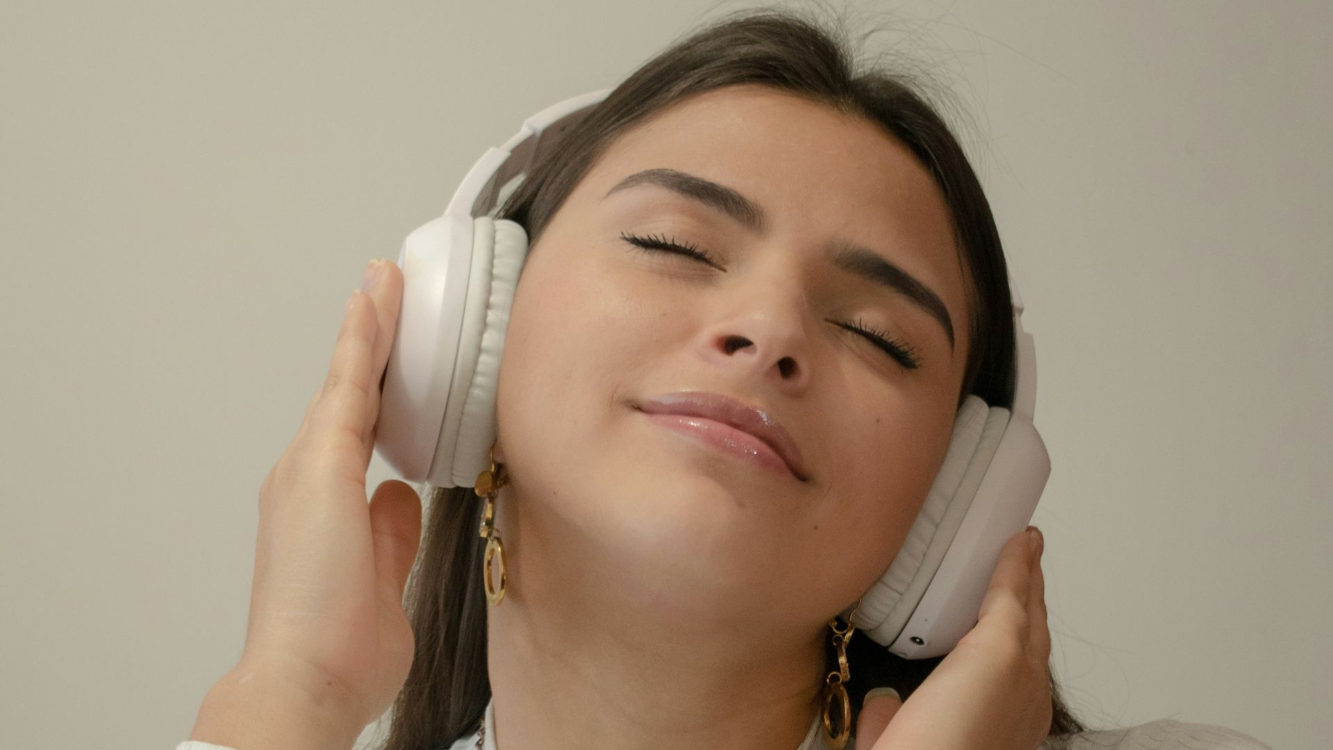 a woman with her eyes closed holding a phone to her ear