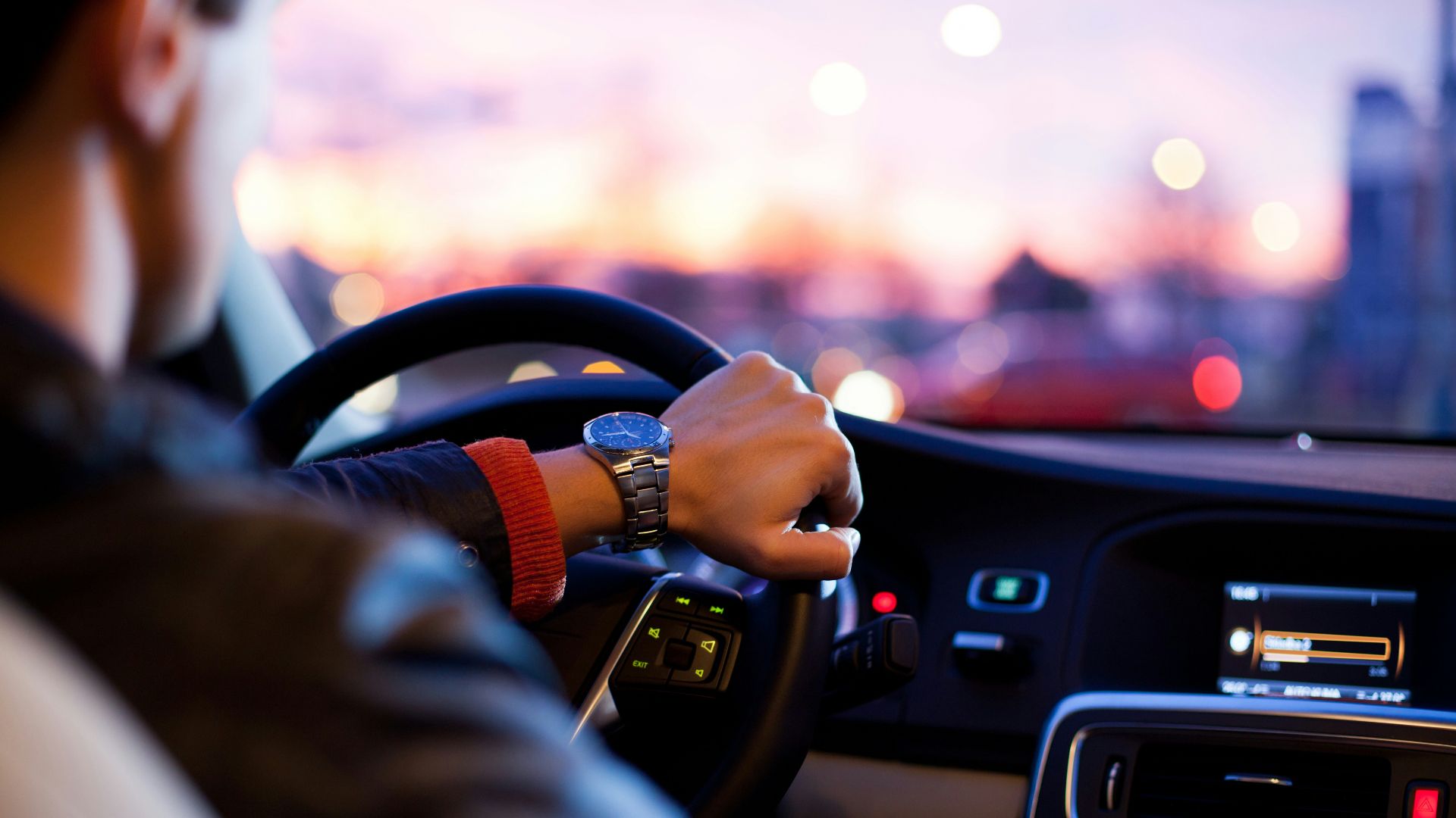 man driving a car wearing wrist watch