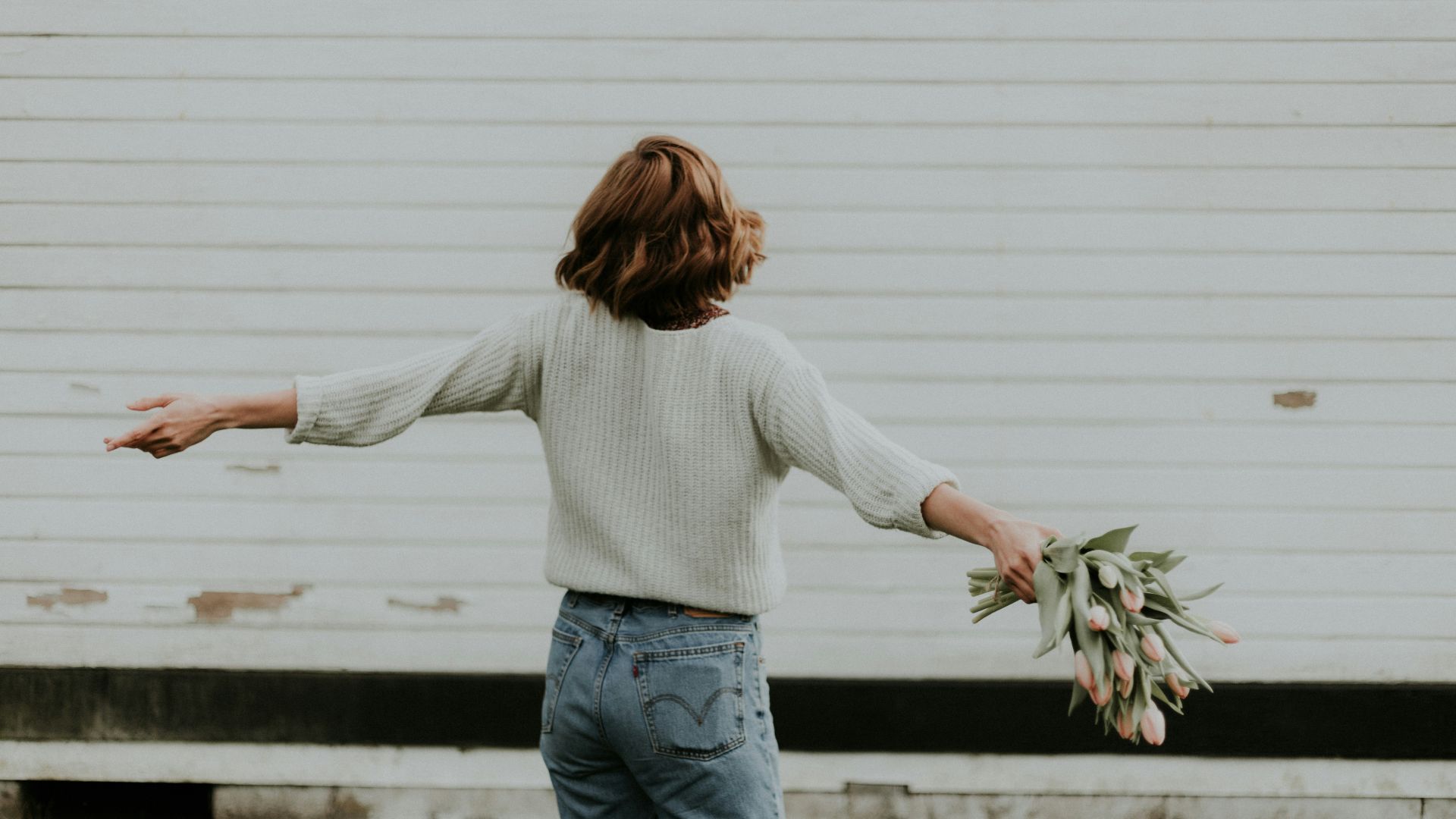 woman holding pink petaled flower