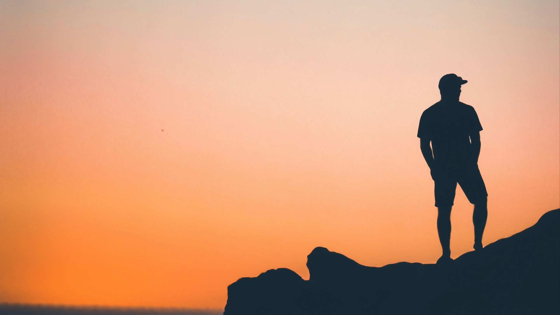 man standing on rock near on seashore