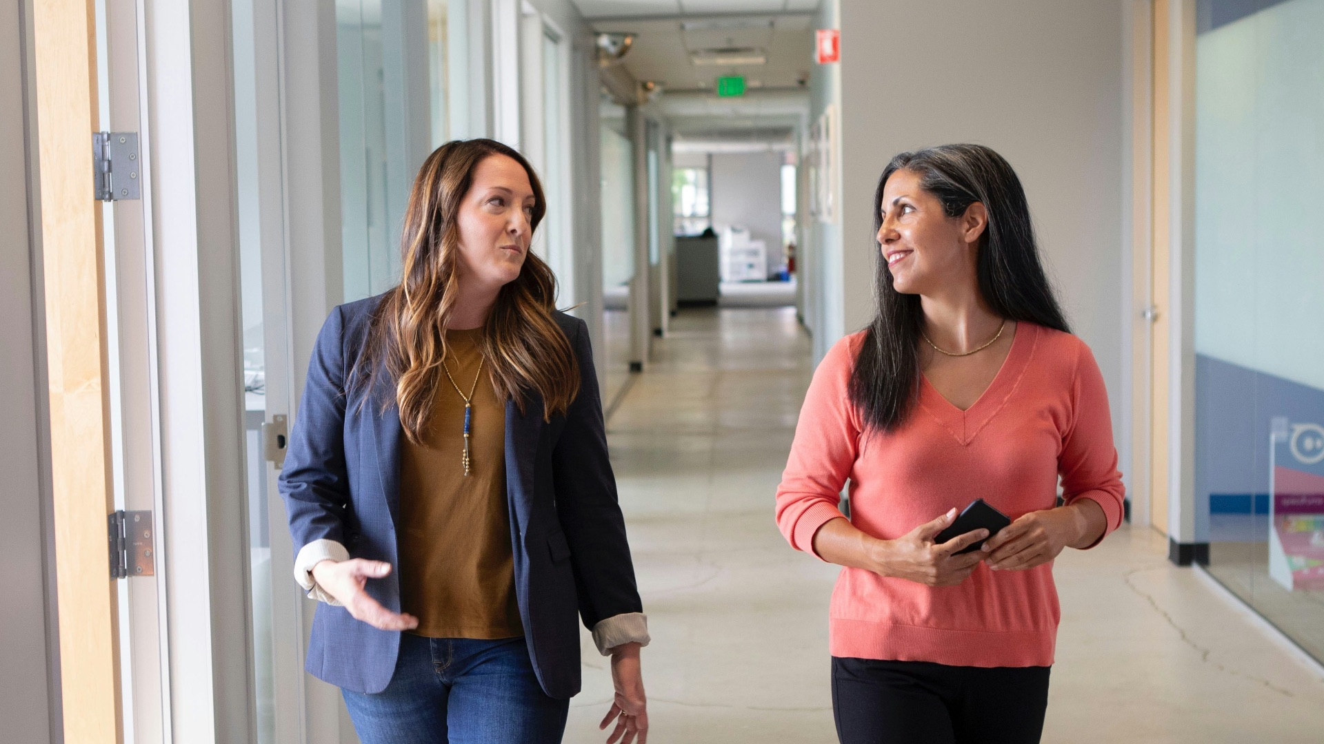 2 women standing near white wall