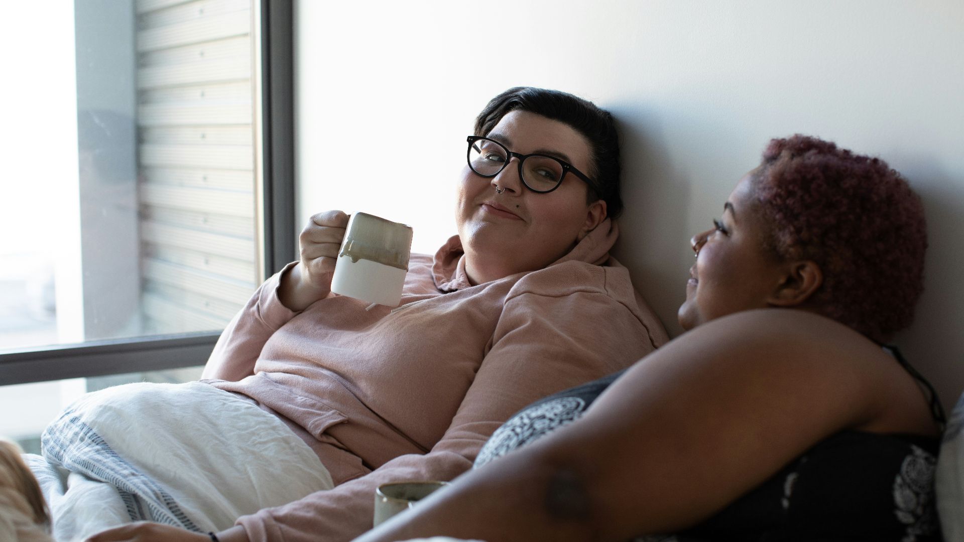two woman lying on bed
