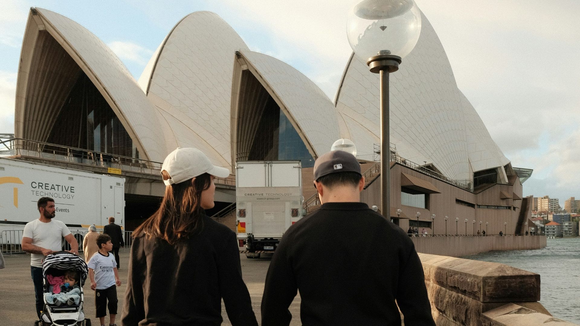 A man and a woman holding hands while walking by the water