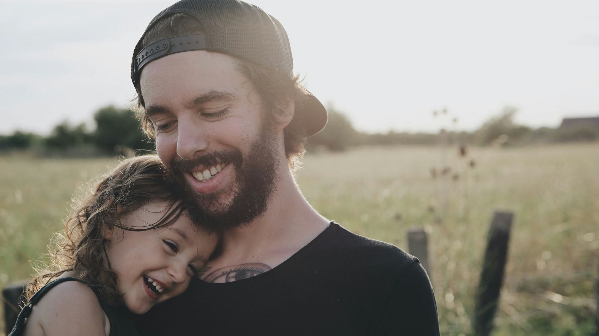 man carrying daughter in black sleeveless top