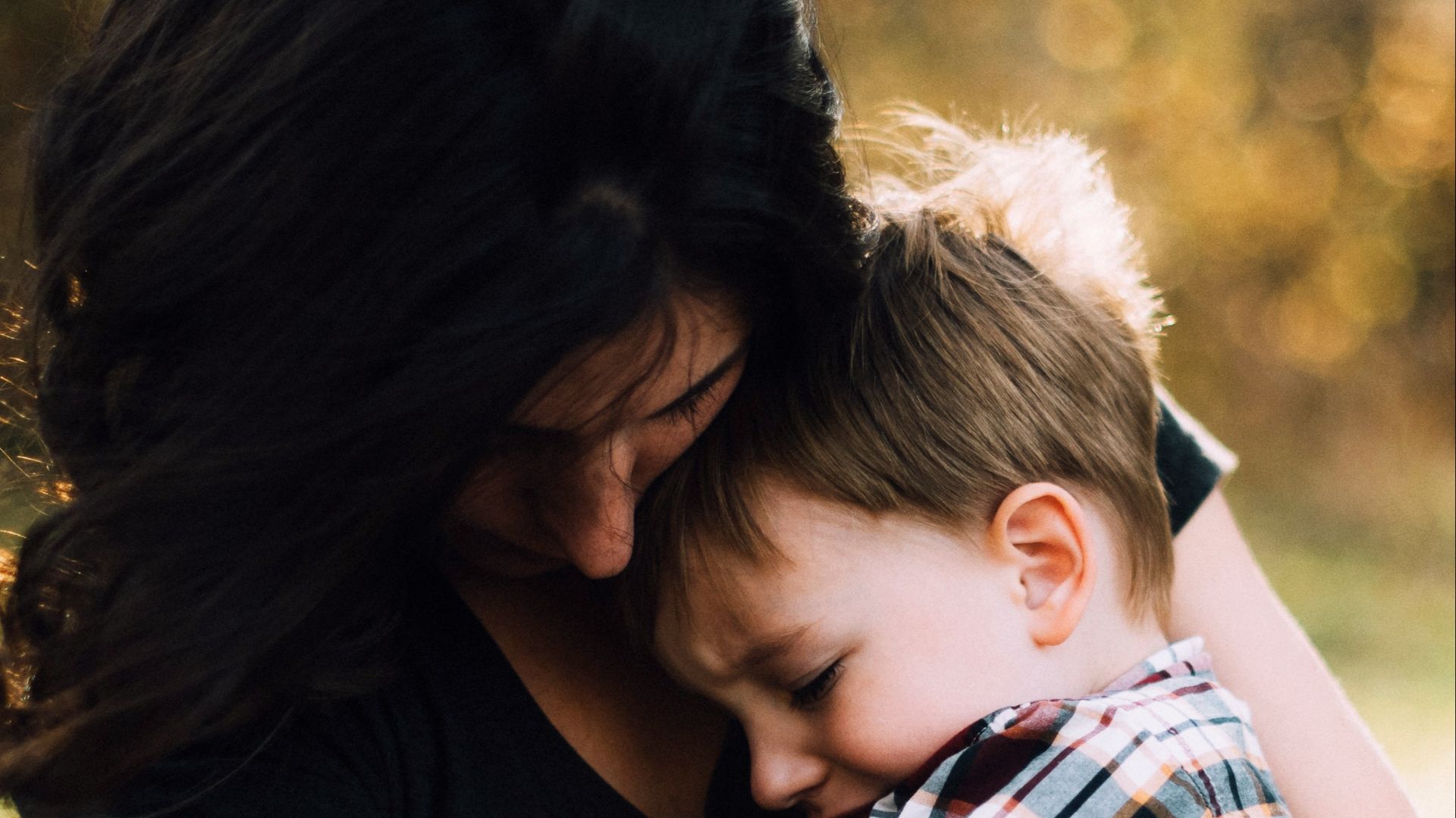 woman hugging boy on her lap