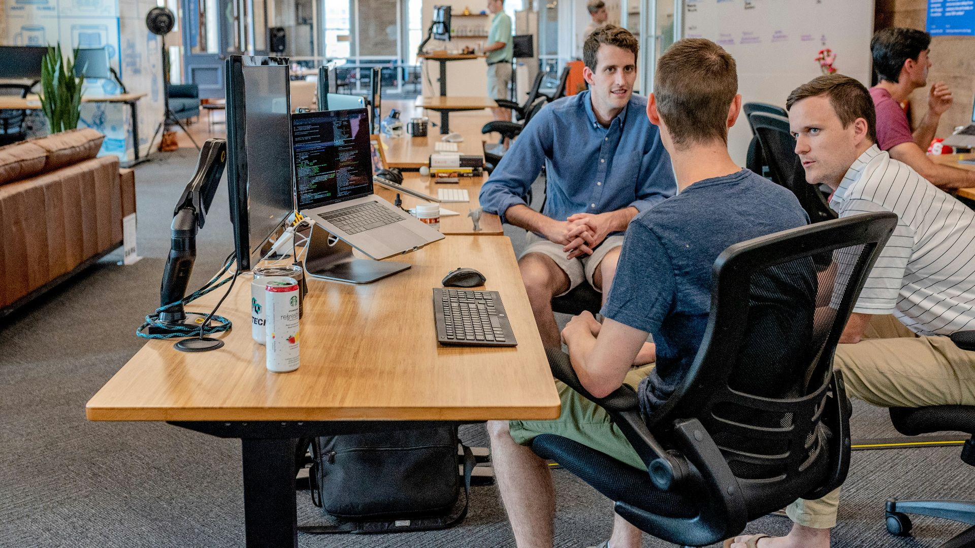 three men sitting on chair beside tables