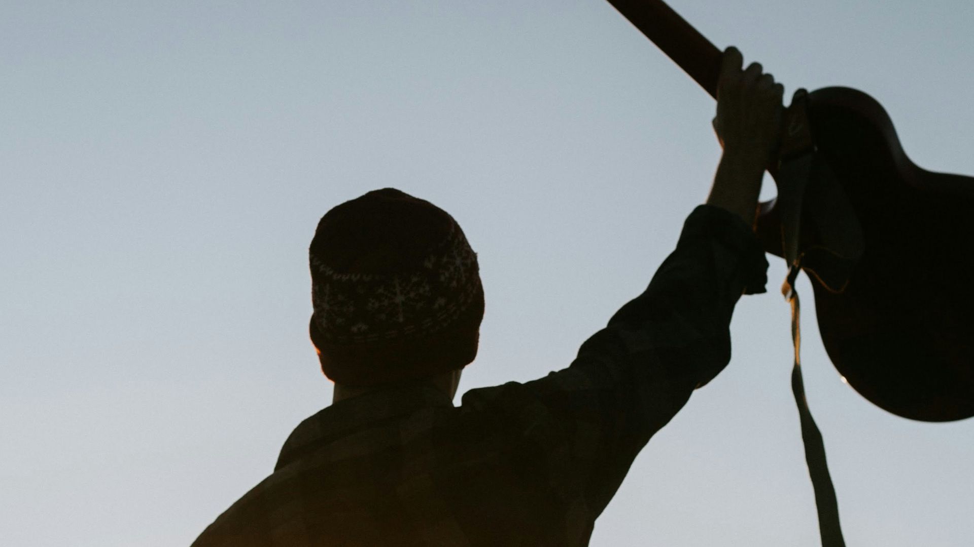man in yellow shirt holding black camera
