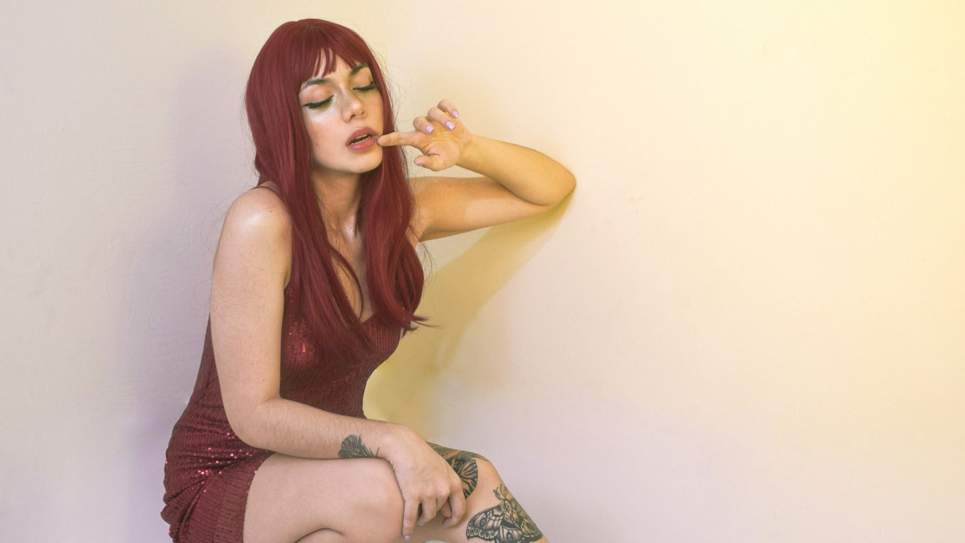 a woman with red hair and tattoos posing for a picture