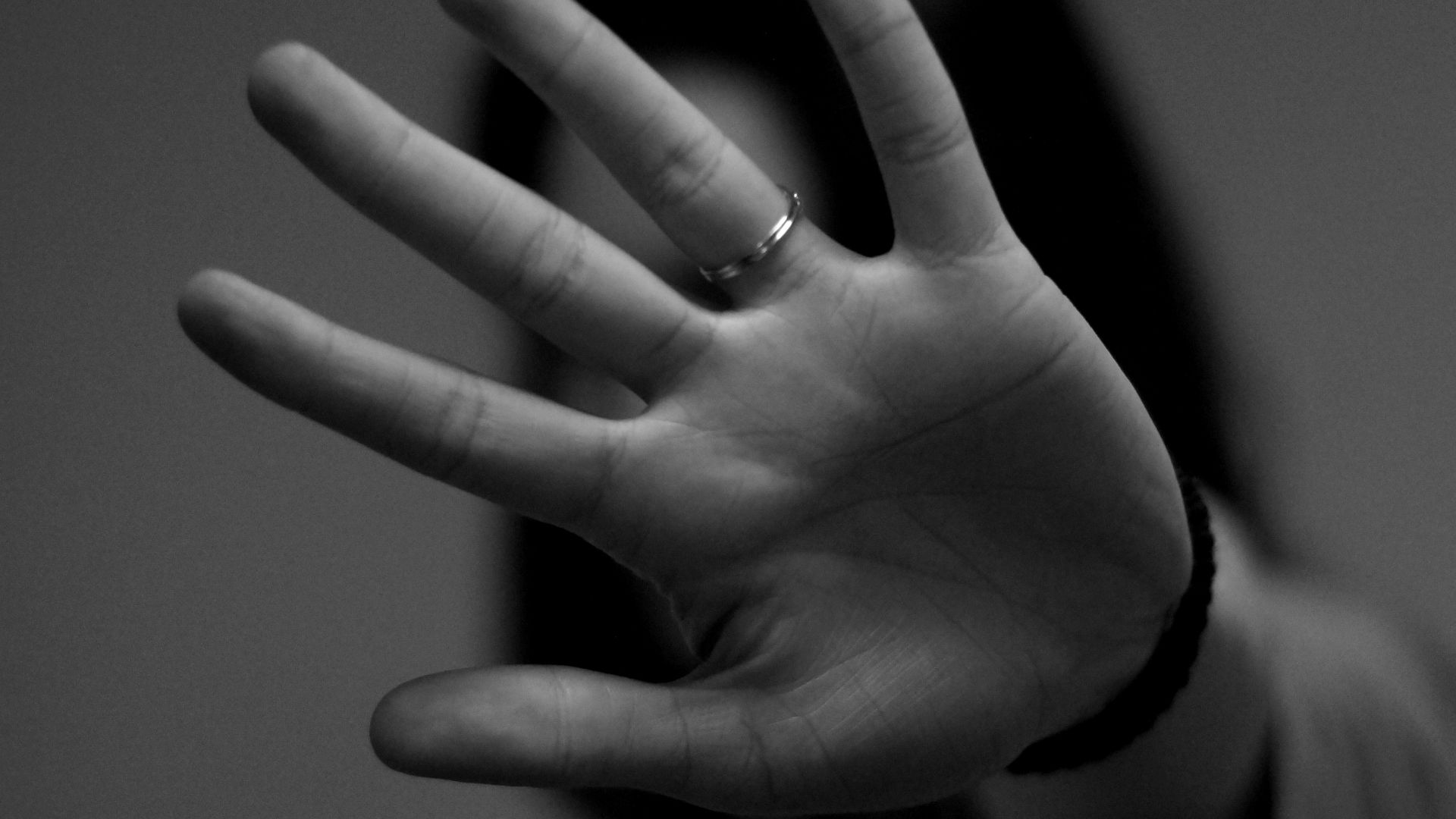woman showing left hand with wedding band