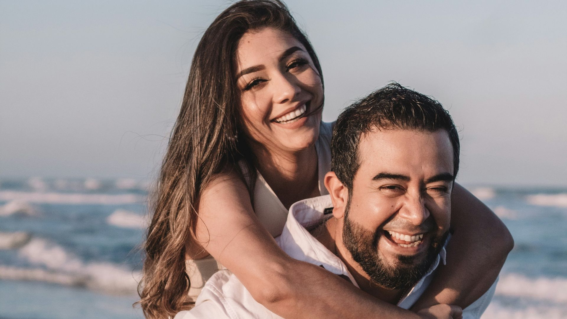 man in white dress shirt hugging woman in white dress