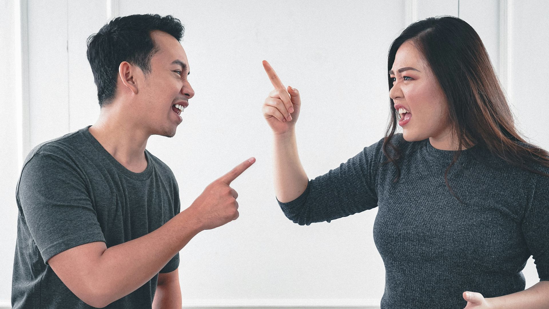 man in gray crew neck long sleeve shirt standing beside woman in black crew neck shirt