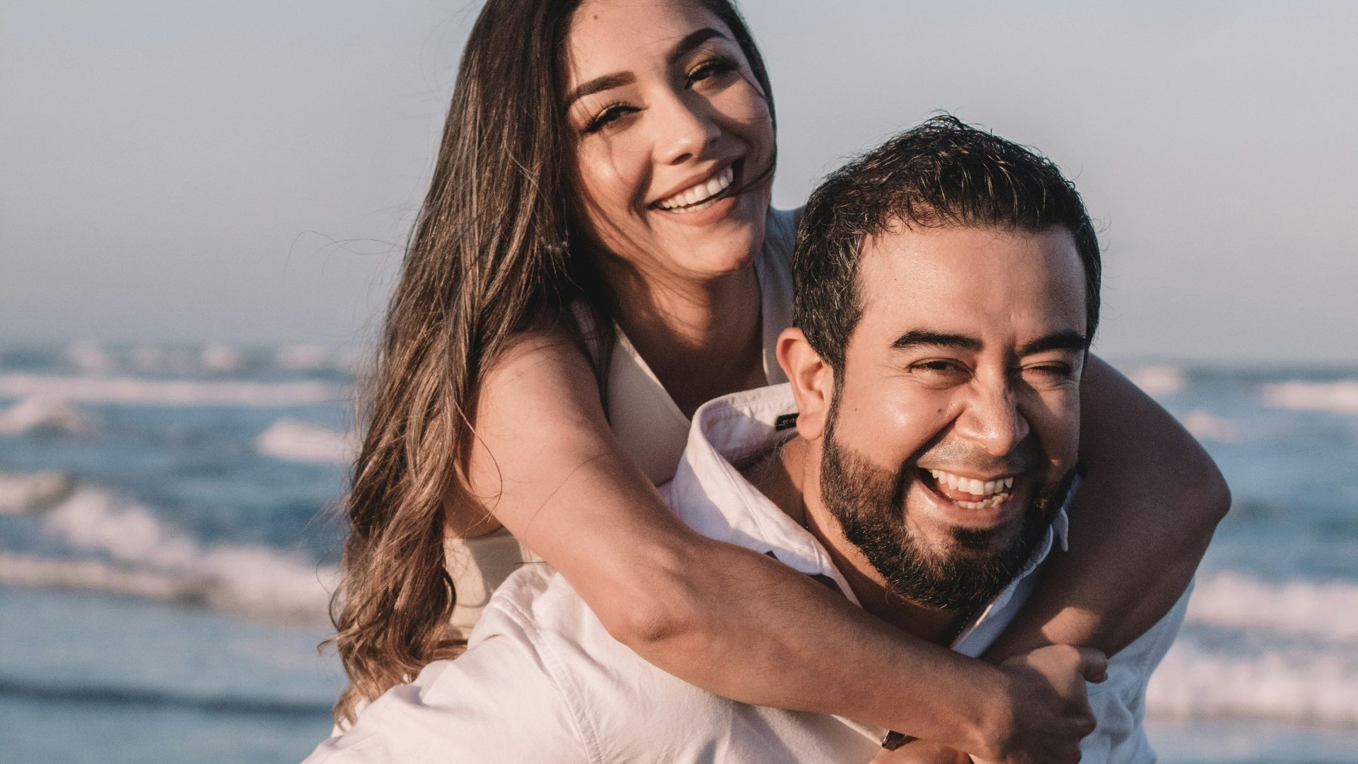 man in white dress shirt hugging woman in white dress