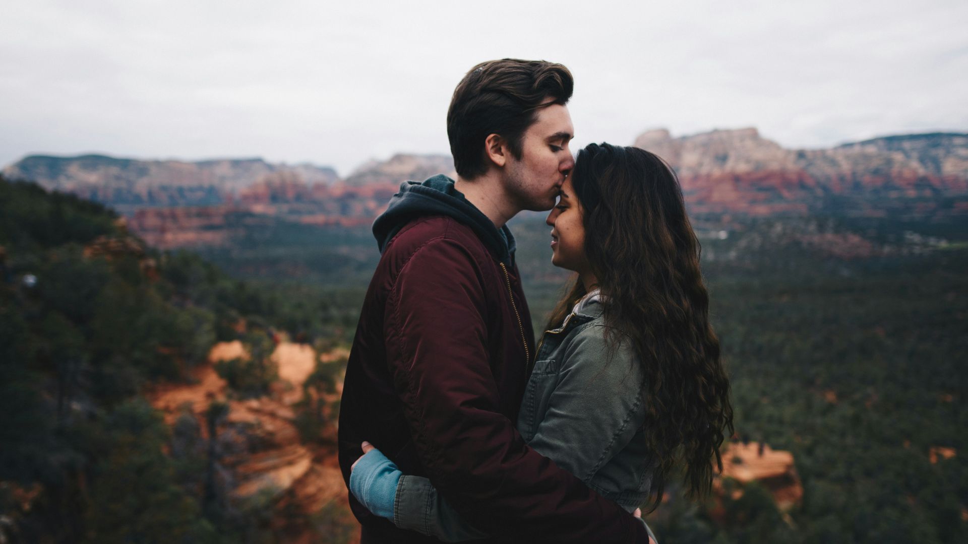 man kissing woman's forehead