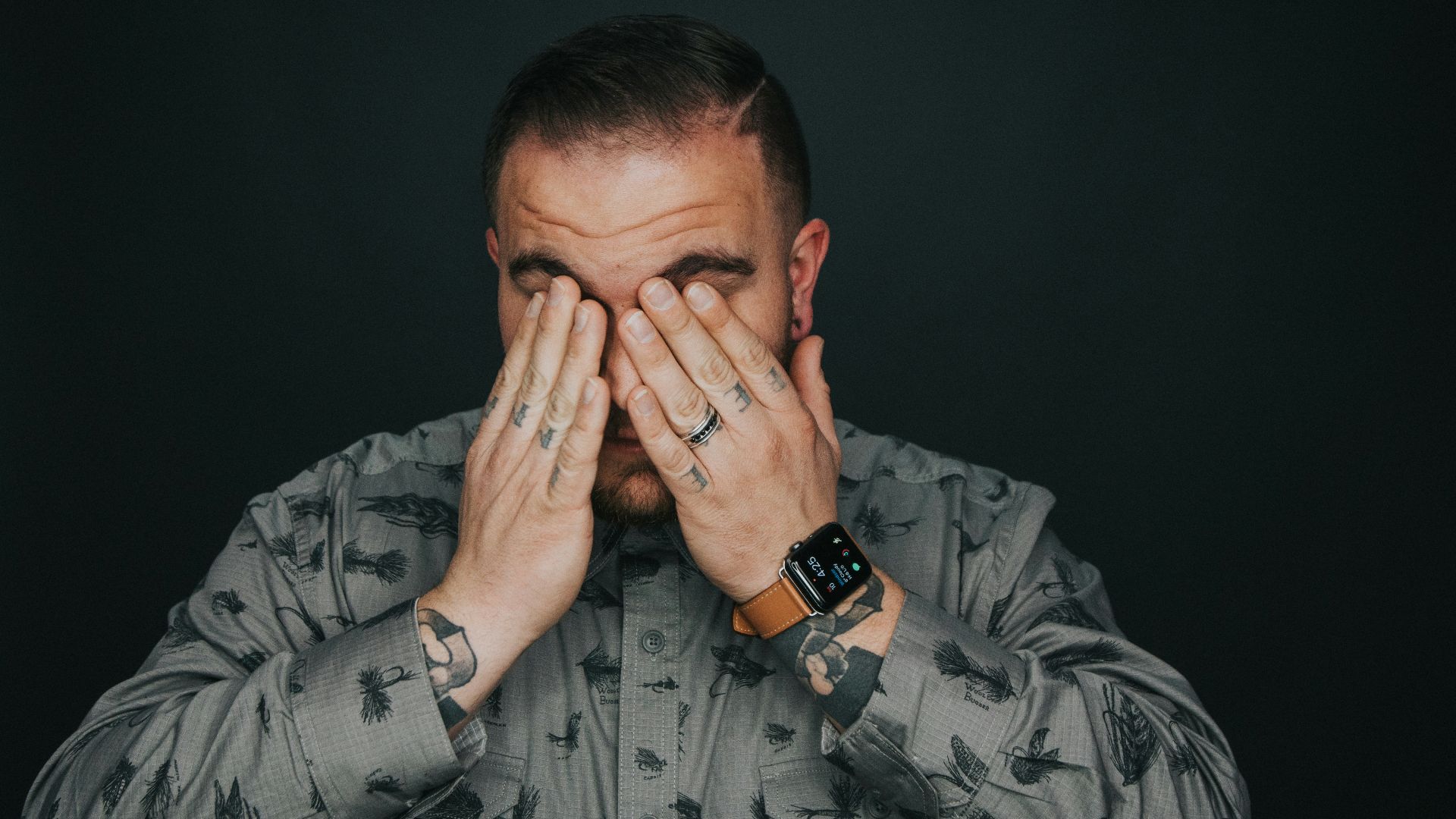 man covering his eye