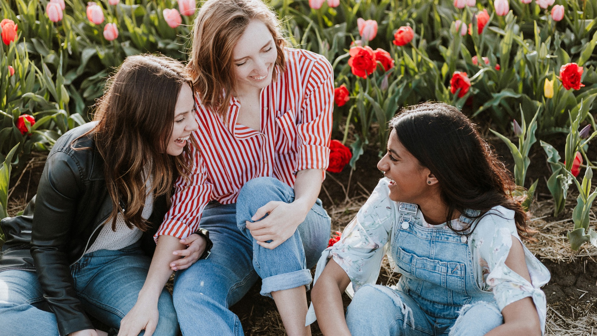 three woman sitting near the flower
