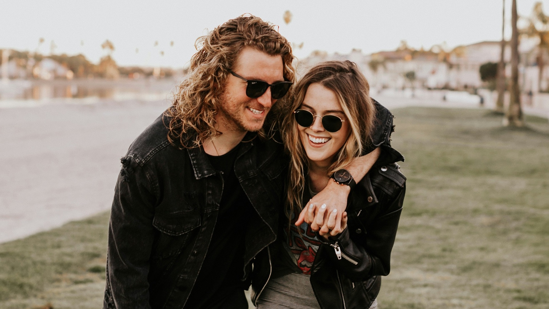 woman in black leather jacket and gray pants standing on green grass field during daytime