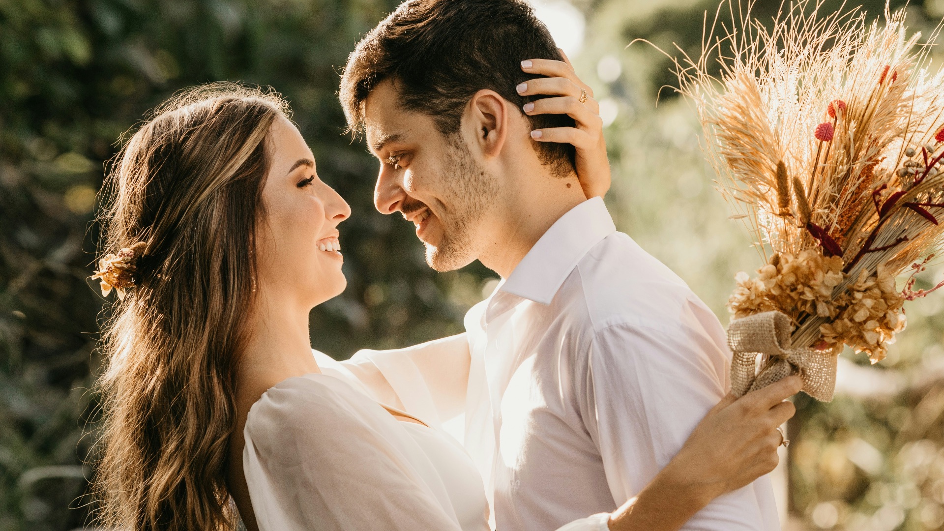 man in white dress shirt holding brown flower bouquet