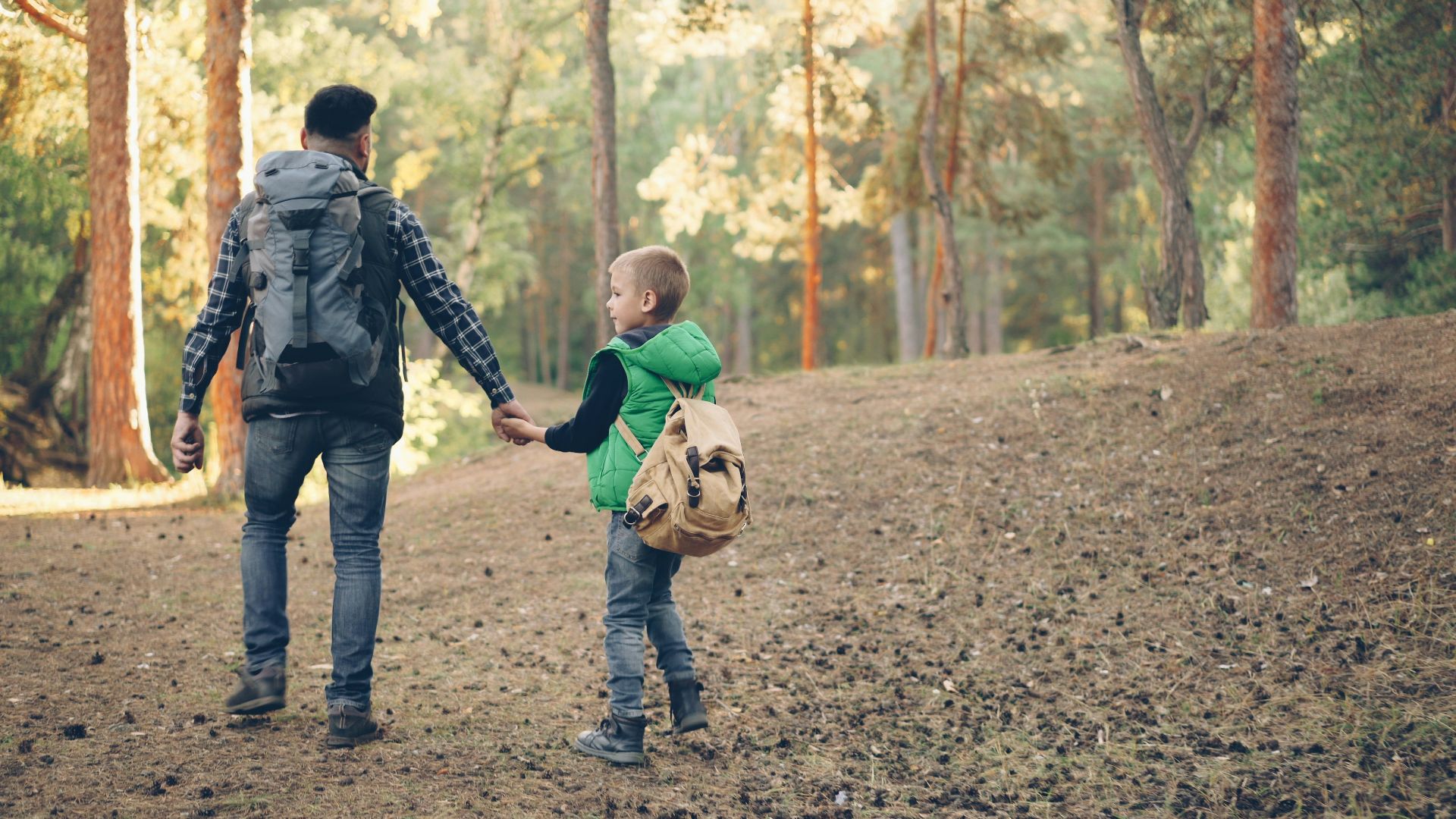 Father and son hike together in the woods.