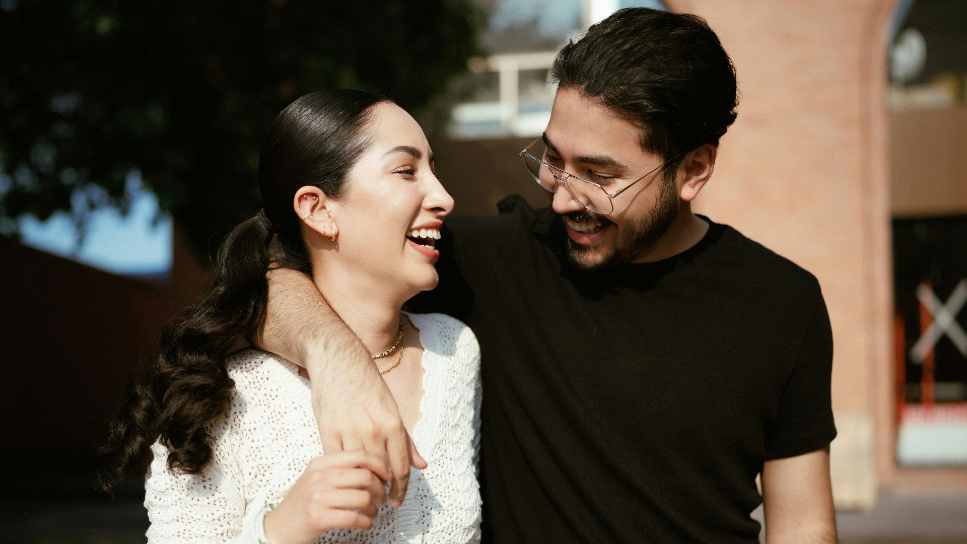 a man standing next to a woman near a tree