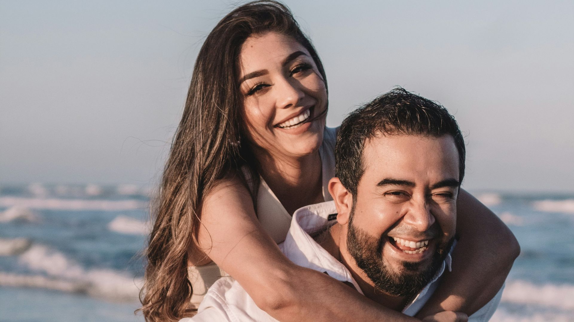 man in white dress shirt hugging woman in white dress