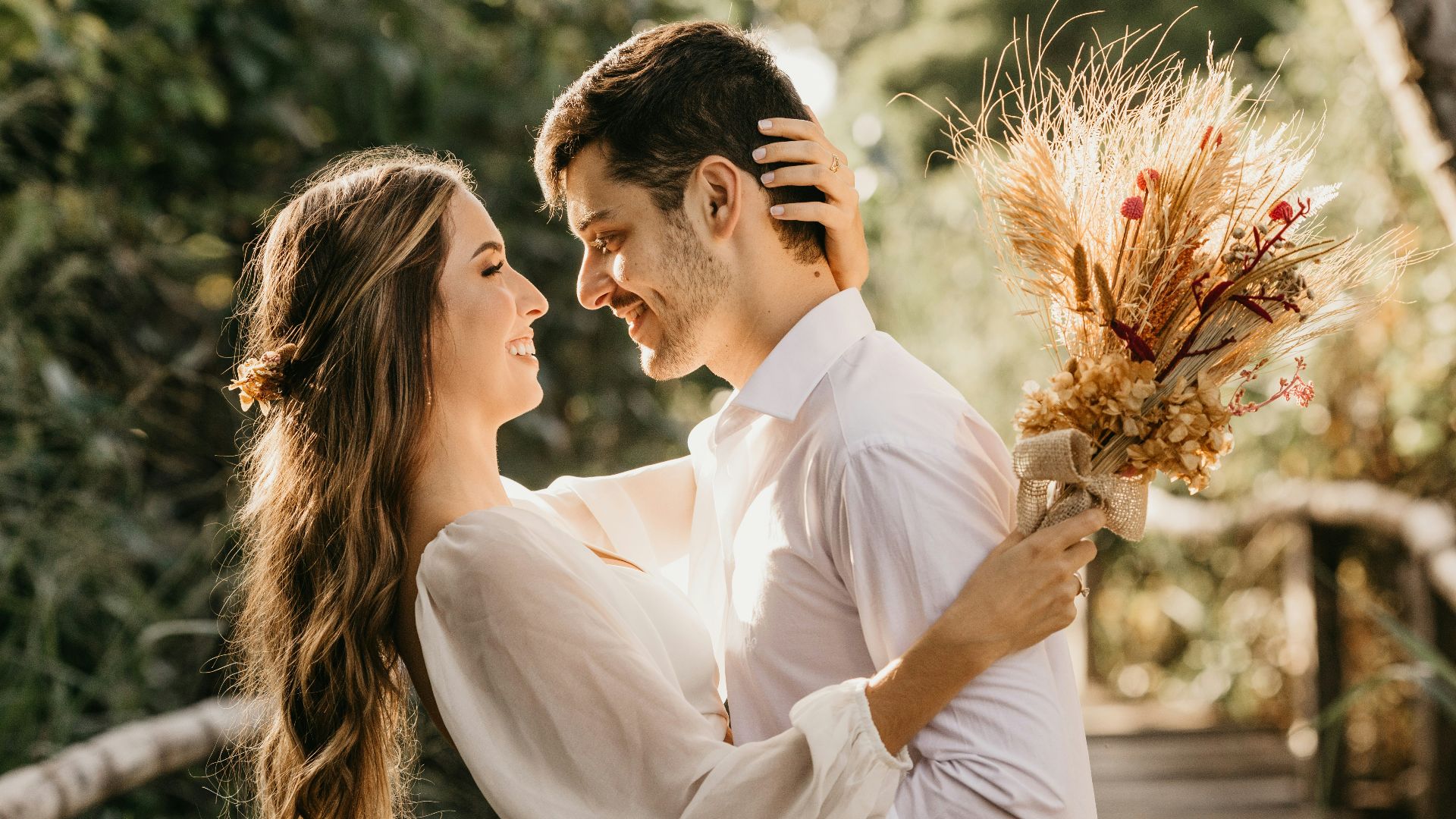 man in white dress shirt holding brown flower bouquet