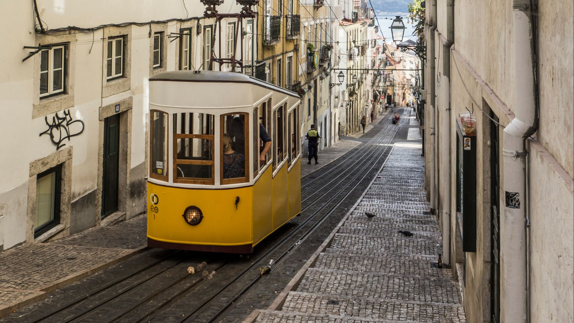 yellow and white bus in the middle of white buildings during daytime