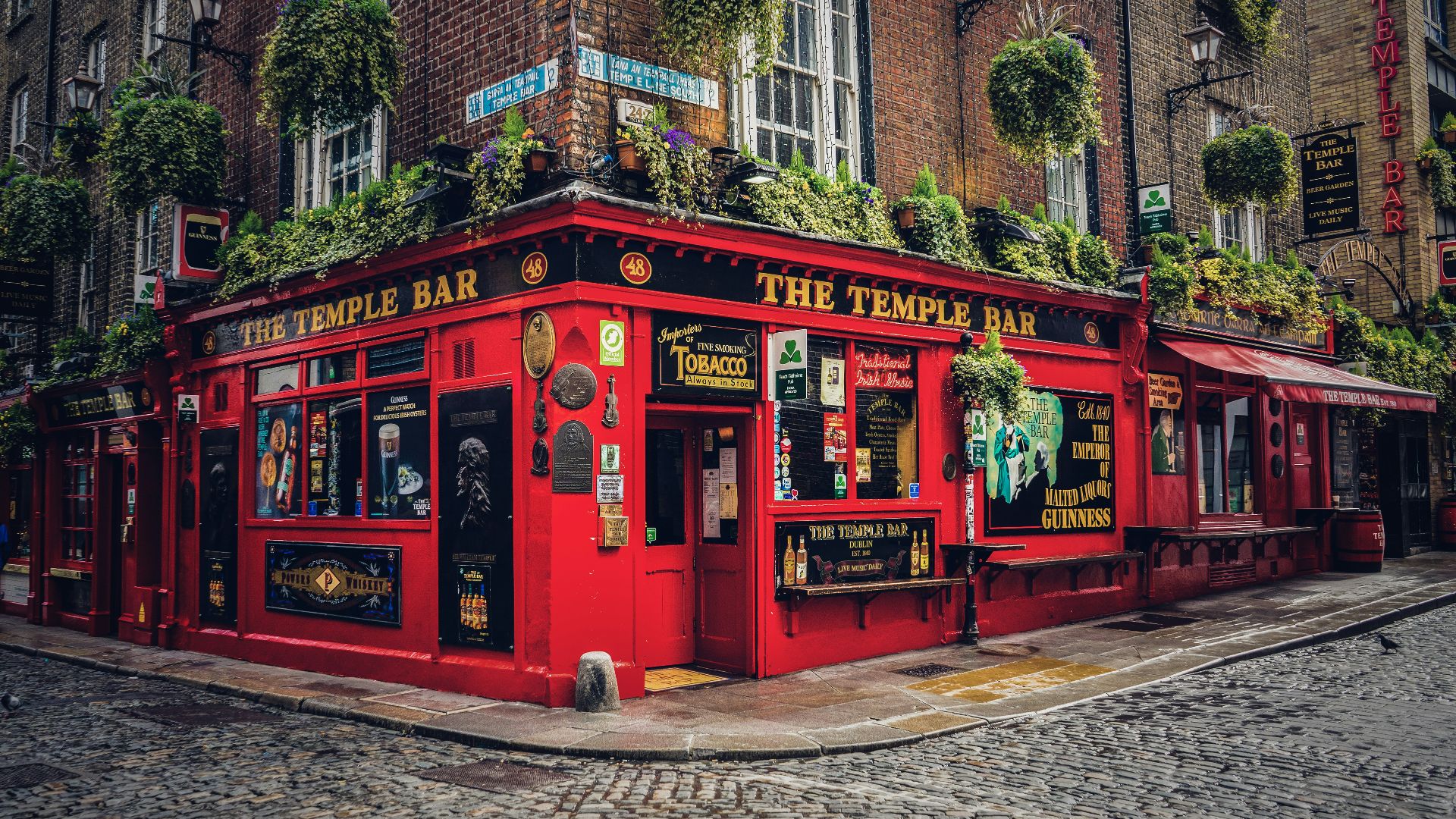 a red building with a bunch of plants on top of it