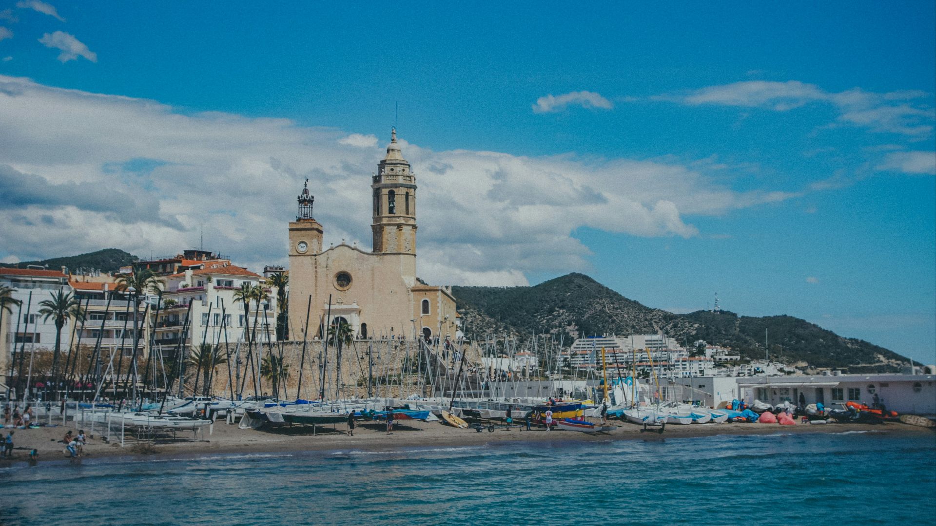 a large building sitting on top of a beach next to a body of water