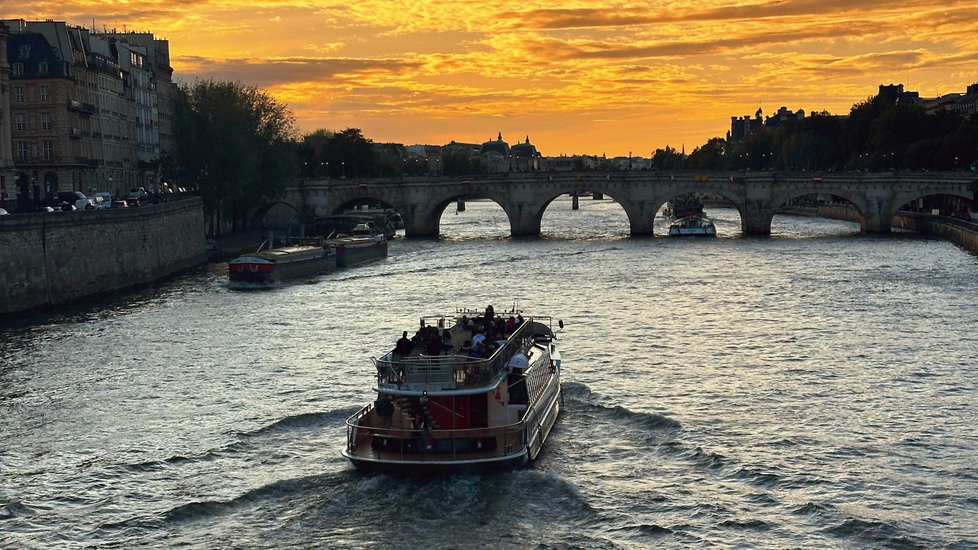 a boat traveling down a river with a bridge in the background