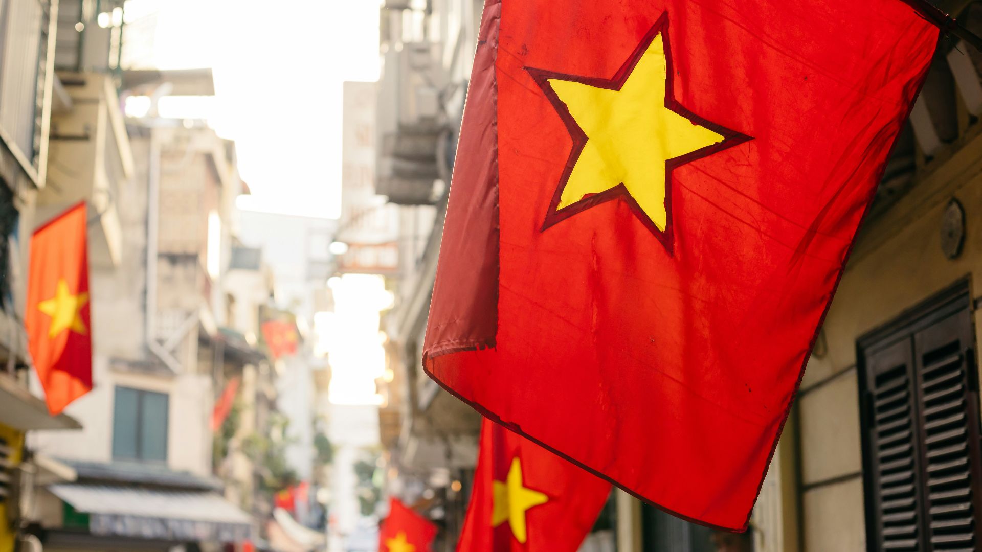a red and yellow flag hanging from the side of a building