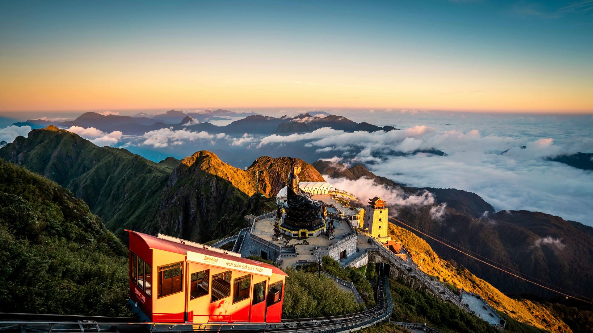 A red and yellow train traveling down a mountain side